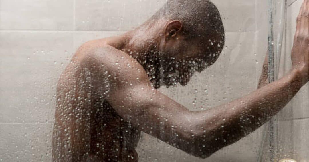Person taking shower with natural handcrafted soap for healthy skin
