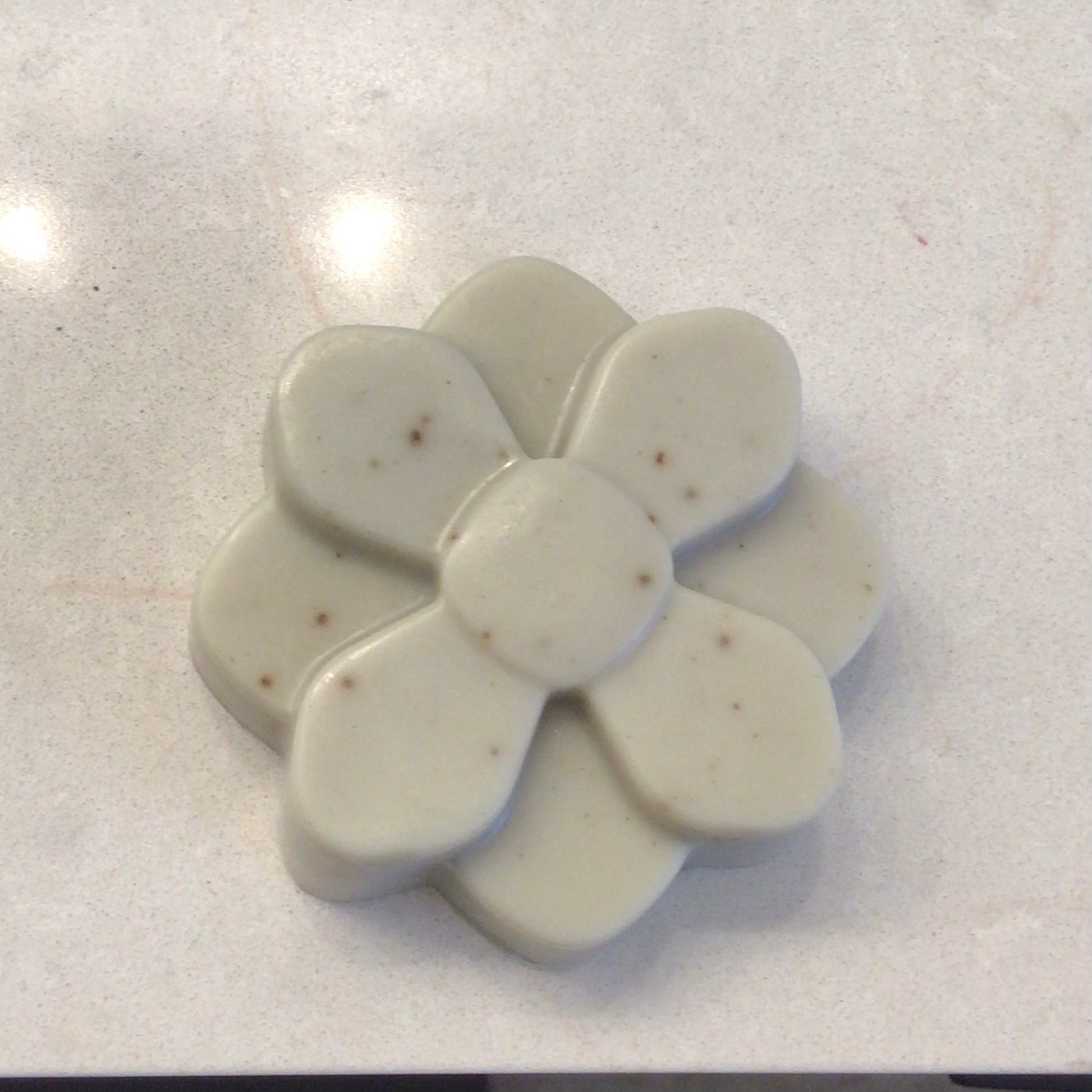Handcrafted French Green Clay daisy flower-shaped Facial Bar with fresh petals on warm wood — The Clay Collection | Handcrafted Soaps by SynEb
