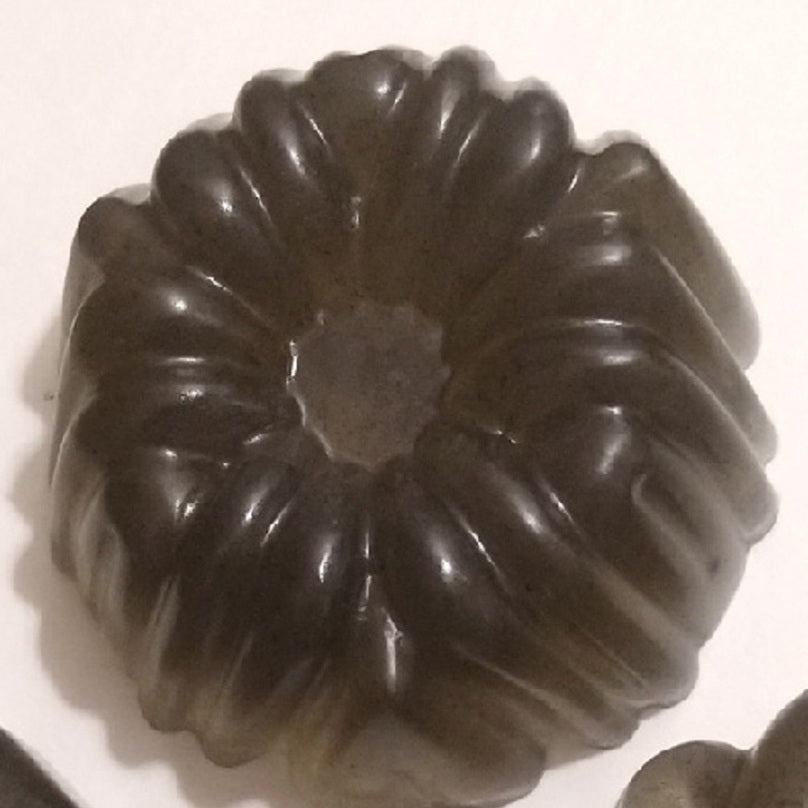 diagonal ribbed/twisted fluting all the way around, like a classic bundt cake mold with a small center hole