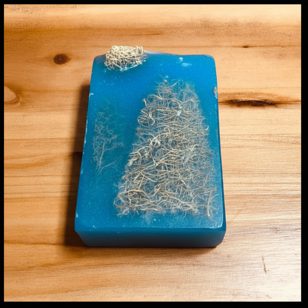 Close-up of Handcrafted Soaps by SynEb Organic Exfoliating Bar showing embedded loofah fruit on natural wood surface